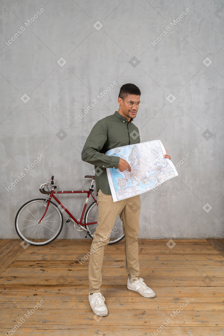 一名男子拿着并指着地图的四分之三视图