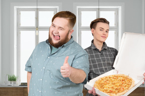 A man with pizza standing next to a man with thumbs up