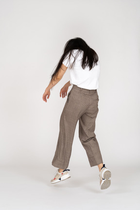 Three-quarter back view of a young lady in breeches and t-shirt outstretching hands