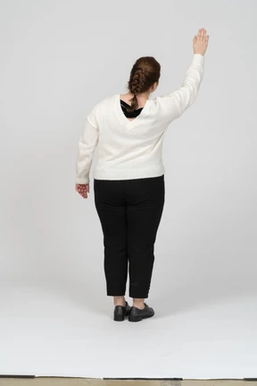 Rear view of a plump woman in casual clothes greeting someone