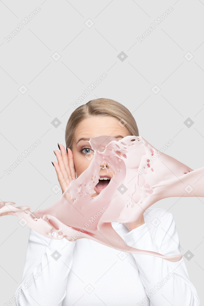 A woman getting splashed in the face with pink liquid