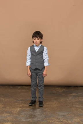 Front view of a boy in grey suit standing still
