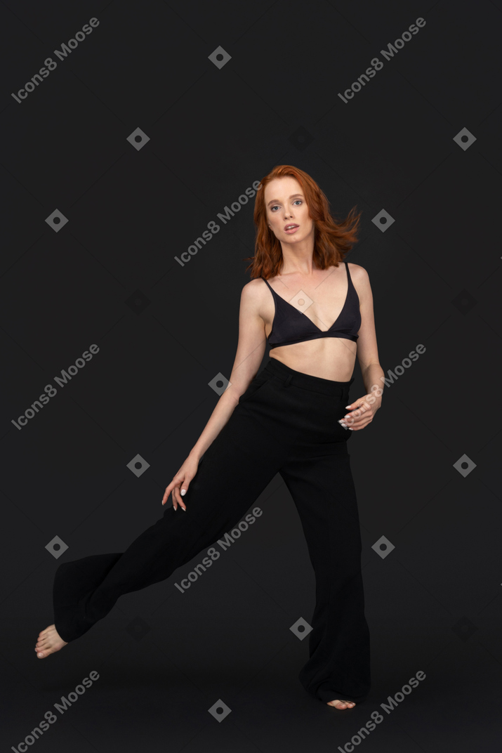 A frontal view of the beautiful woman dressed in black and dancing
