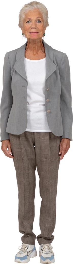 Vista frontal de una anciana en traje mirando a la cámara y haciendo muecas