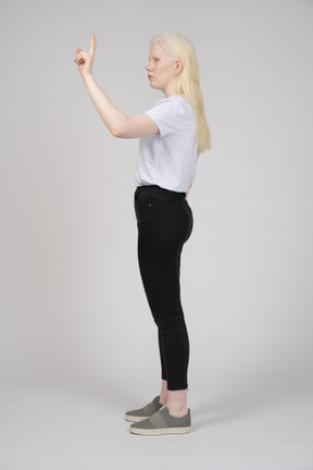 Side view of a young girl with peace hand sign