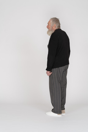 Three-quarter back view of an old man standing