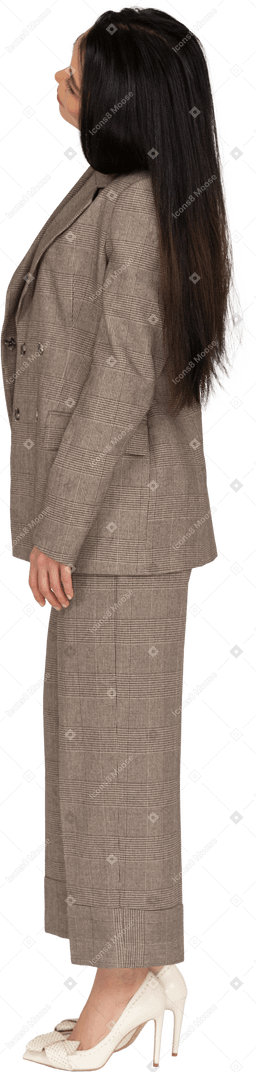 頭を傾ける茶色のビジネススーツの若い女性の側面図