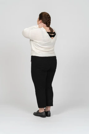 Rear view of a plump woman touching her neck