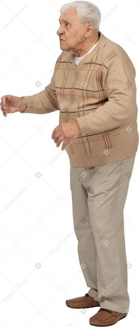 Vista lateral de un anciano enojado con ropa informal mirando hacia arriba