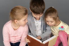 Tre adorabili bambini che leggono baldoria