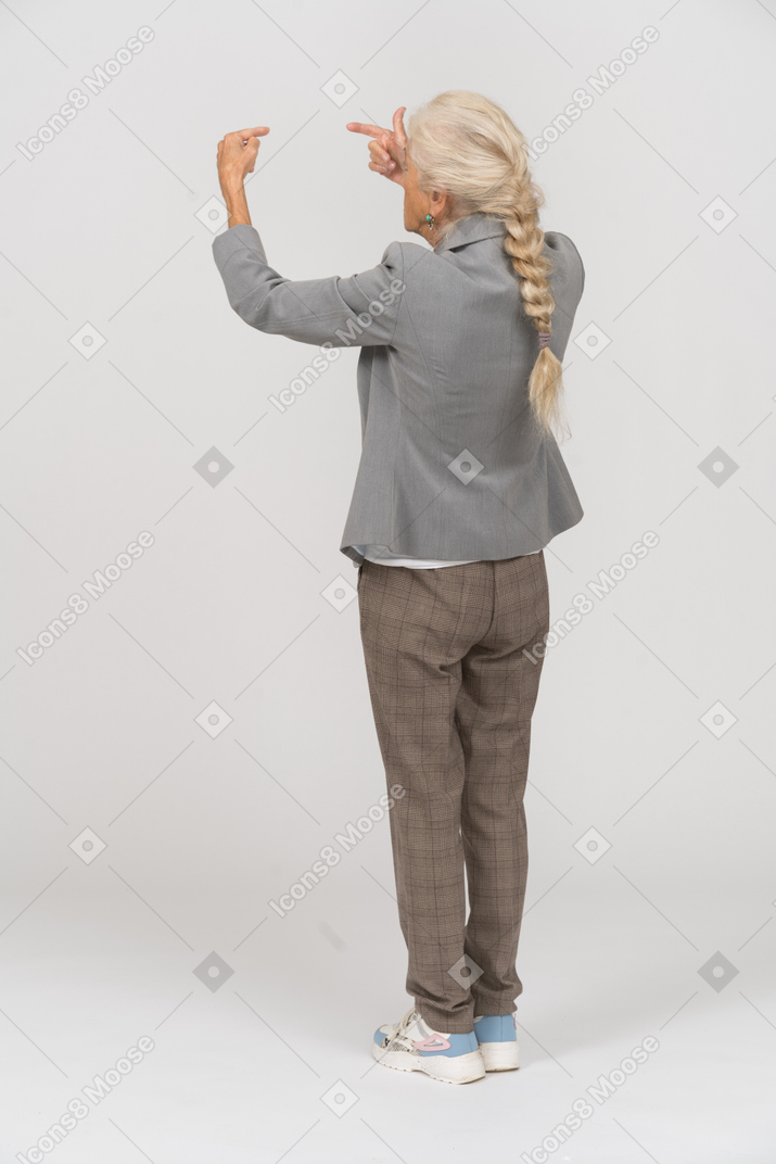 Vista traseira de uma senhora de terno apontando com os dedos