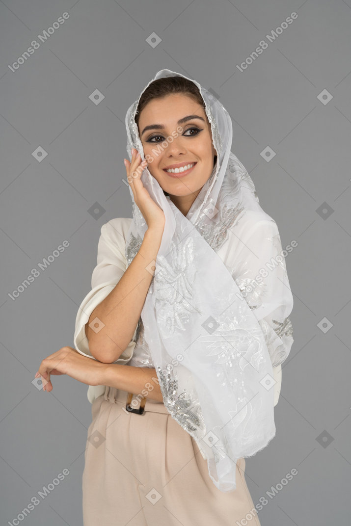 옆으로 보이는 흰색 headscarf를 입고 사랑스러운 젊은 여자