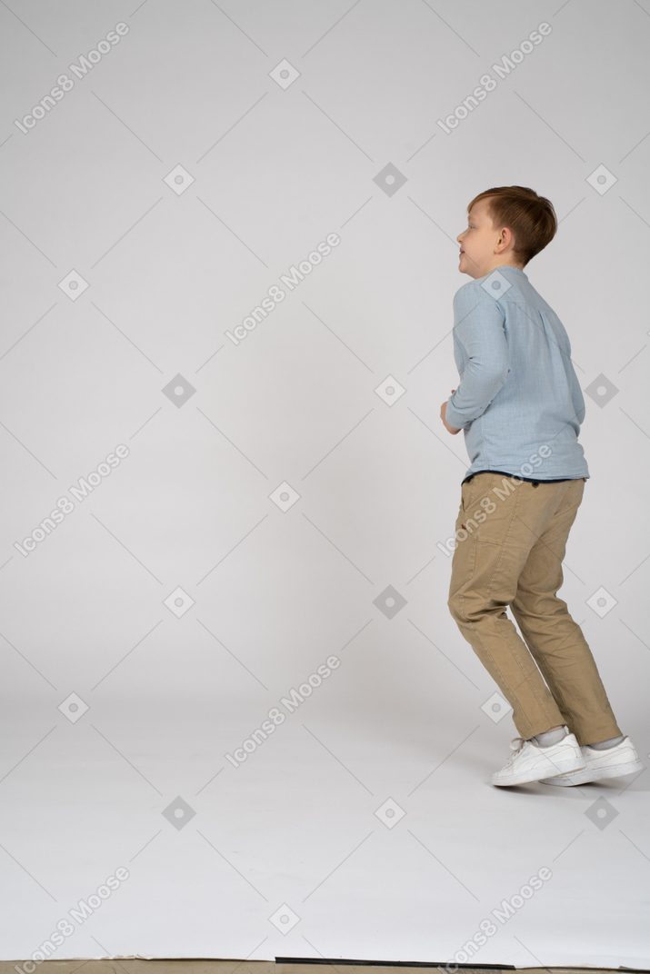 カメラに背を向けて壁の前に立っている男