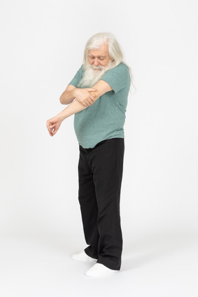 Three-quarter view of old man feeling pain in elbow