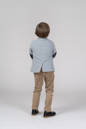 Back view of boy in jacket and trousers