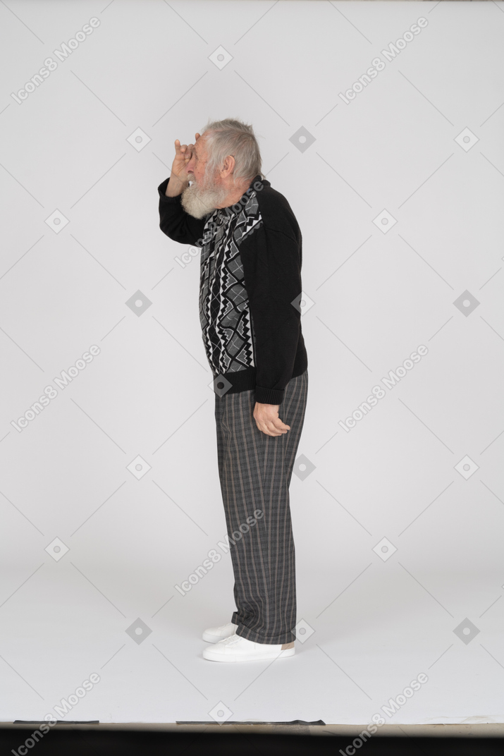 Side view of old man looking into hand telescope