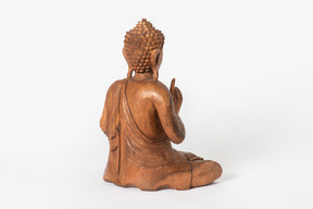 Buddha statue placed half sideways back to camera on white background