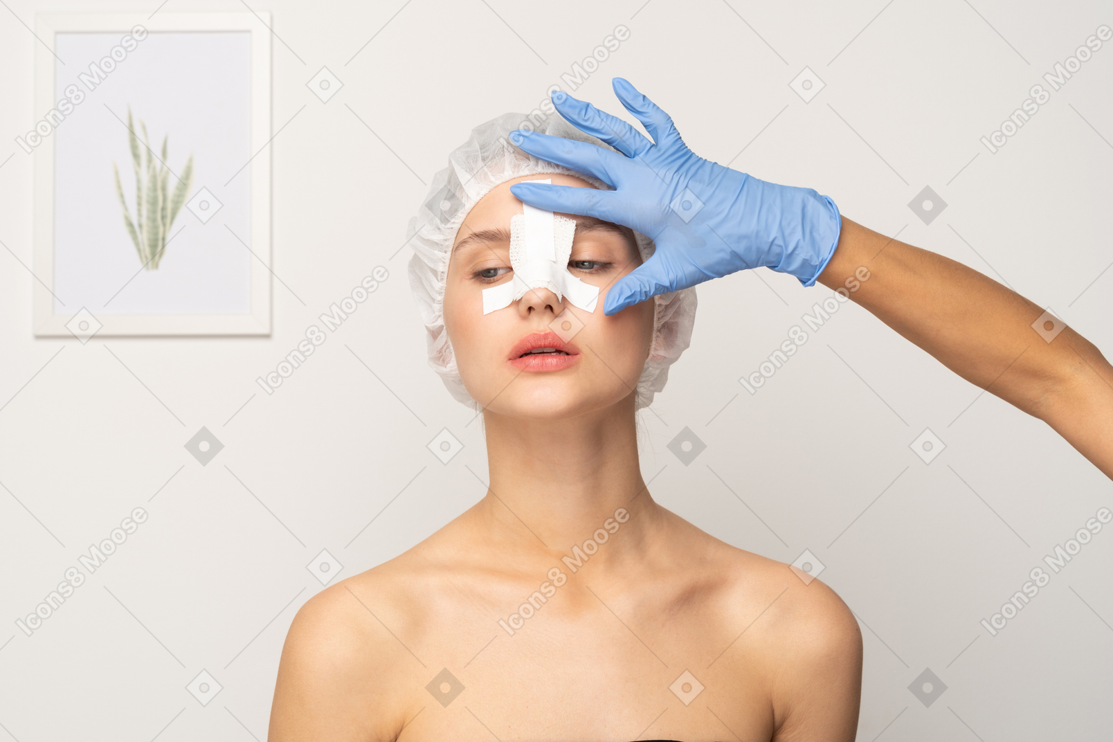 Doctor applying bandage to young woman's nose