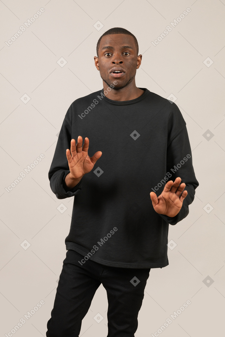 Shocked man standing with raised hands