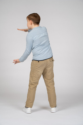 Vista traseira de um menino mostrando o tamanho de algo