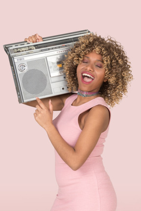 A woman in a pink dress holding a radio