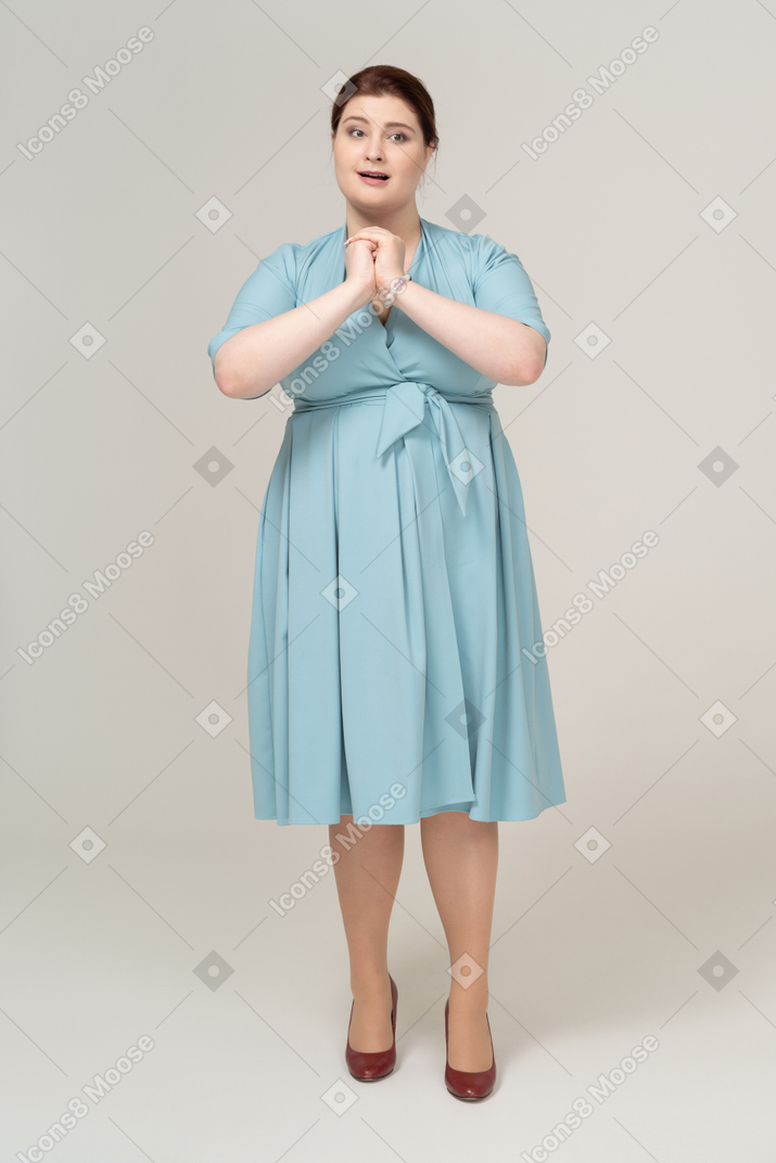 Mujer feliz en vestido azul mirando a la cámara