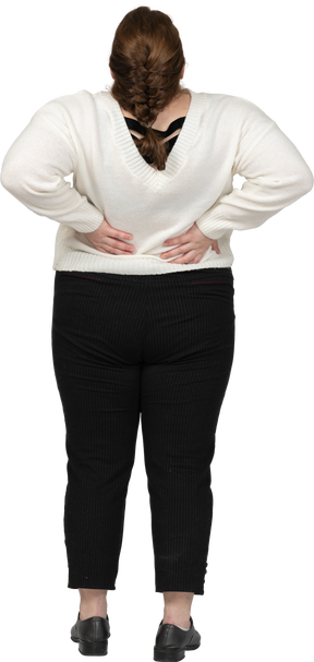 Mujer de talla grande en suéter blanco que sufre de dolor en la espalda baja