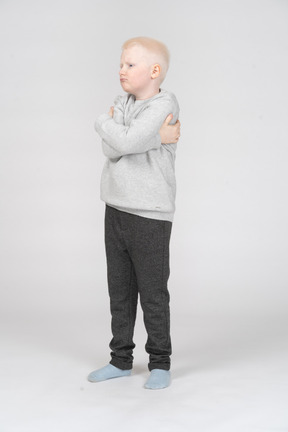 Three quarter view of a little boy with crossed hands
