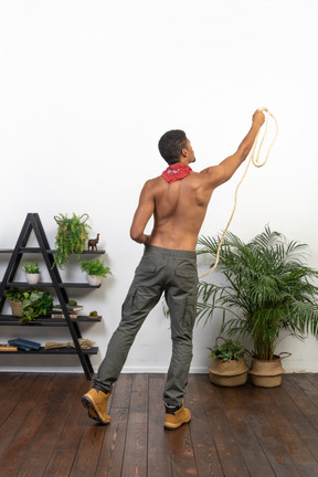 Rear view of athletic man throwing a rope