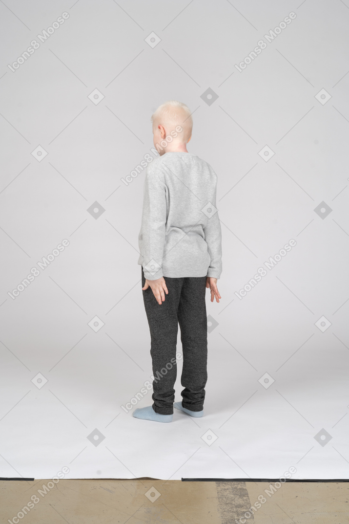 Vista traseira de três quartos de um menino em pé
