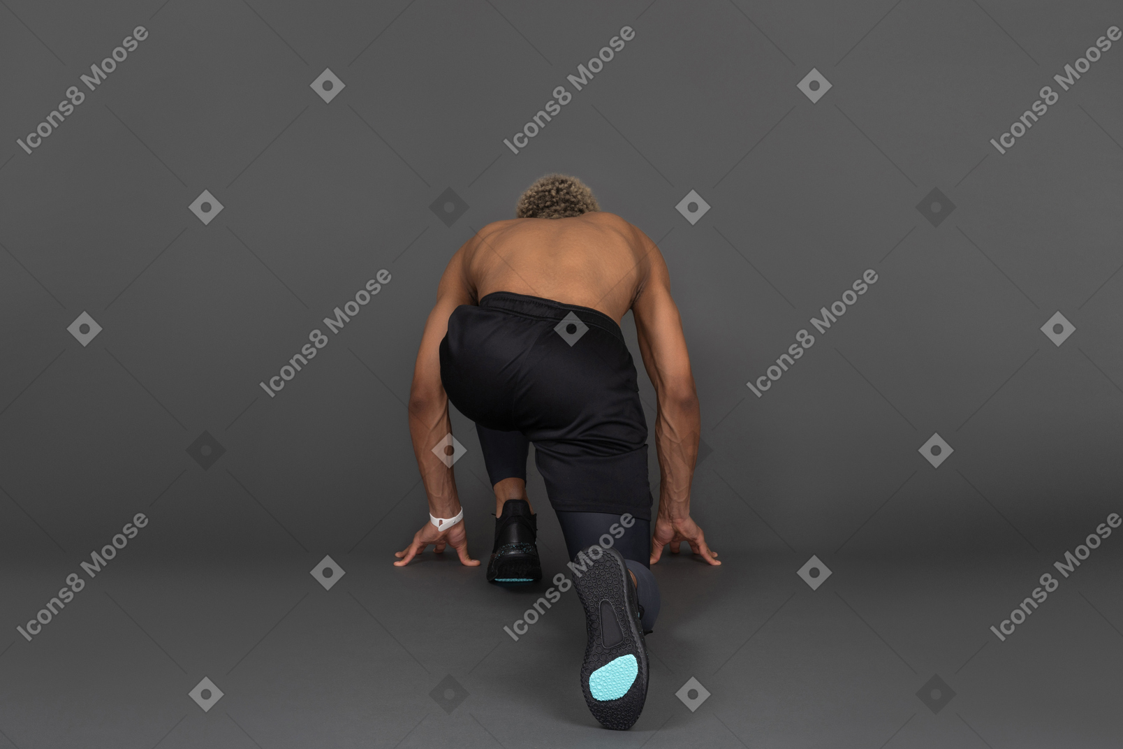 Back view of a shirtless dark-skinned sprinter ready to run
