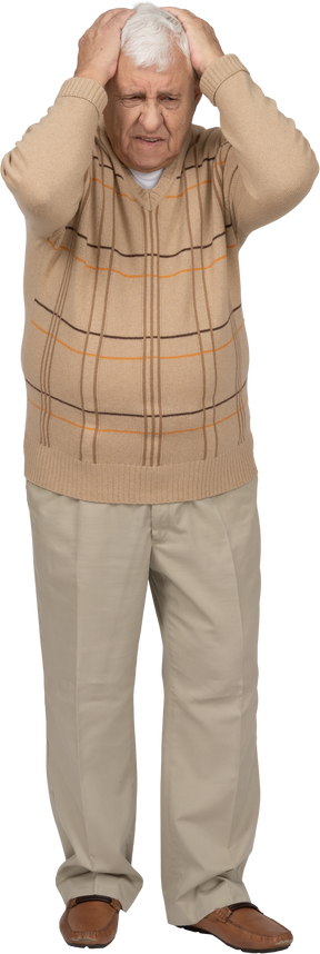 Vista frontal de un anciano con ropa informal de pie con las manos en la cabeza