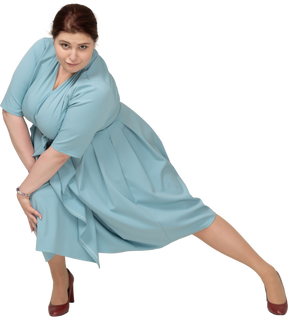 Vista frontal de uma mulher de vestido azul se exercitando