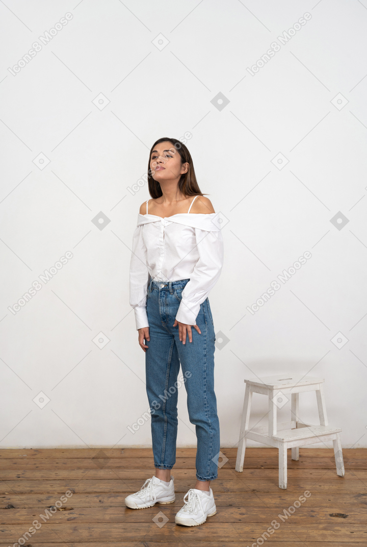 A woman standing in front of a white wall