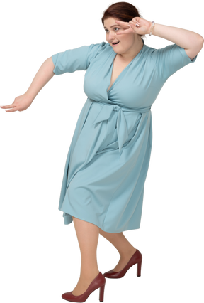 Vista laterale di una donna in abito blu che mostra il segno v