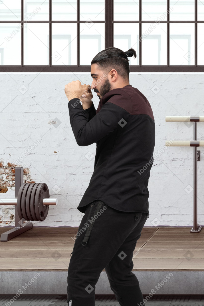 Man in boxing stance standing in gym