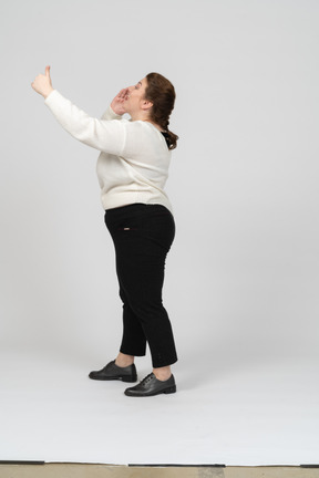 Side view of a plump woman in casual clothes with raised arm