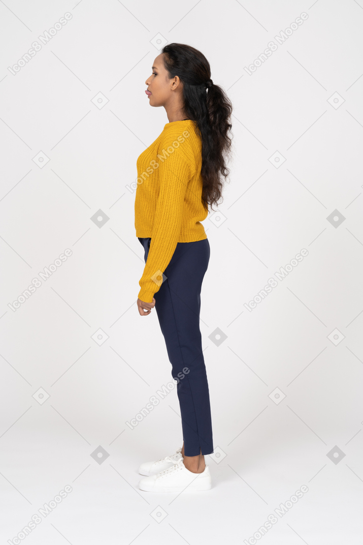 Side view of a girl in casual clothes showing tongue