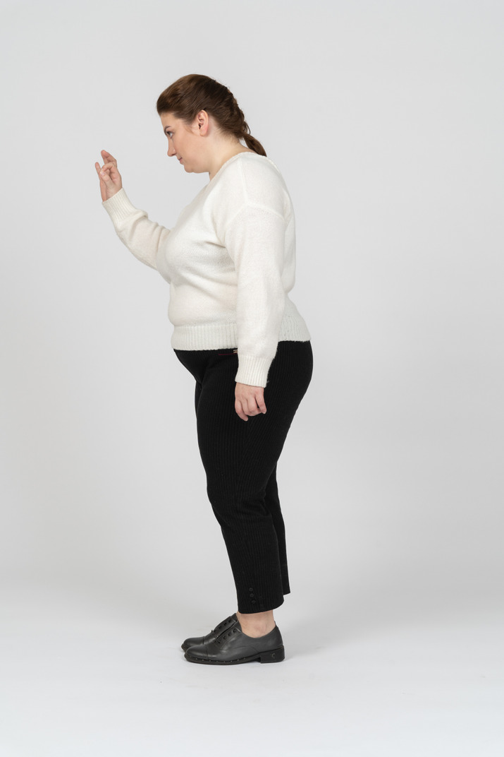 横顔に立つカジュアルな服装のふくよかな女性 のフォト