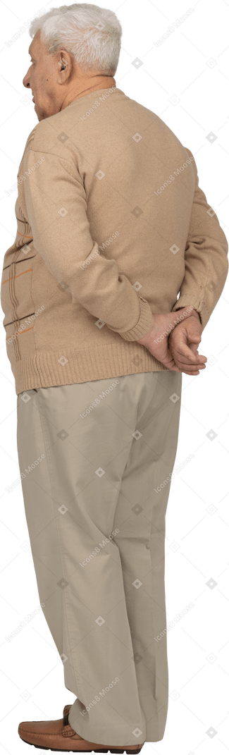 Вид сзади на старика в повседневной одежде, стоящего с руками за спиной
