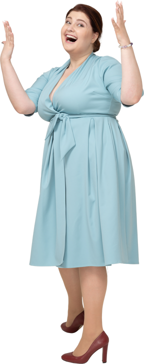 Vista frontal de una mujer feliz en vestido azul gesticulando
