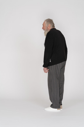 Three-quarter back view of an old man standing with open mouth