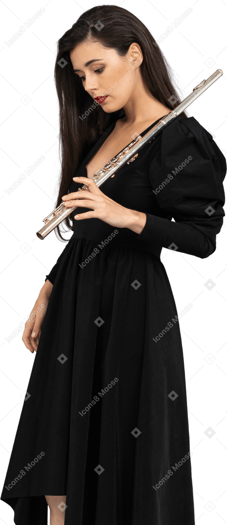 Three-quarter view of a serious young lady in black dress holding flute and looking down