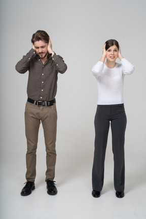 Front view of a young couple in office clothing touching head