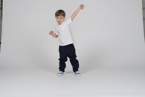 Front view of a little boy raising his arm