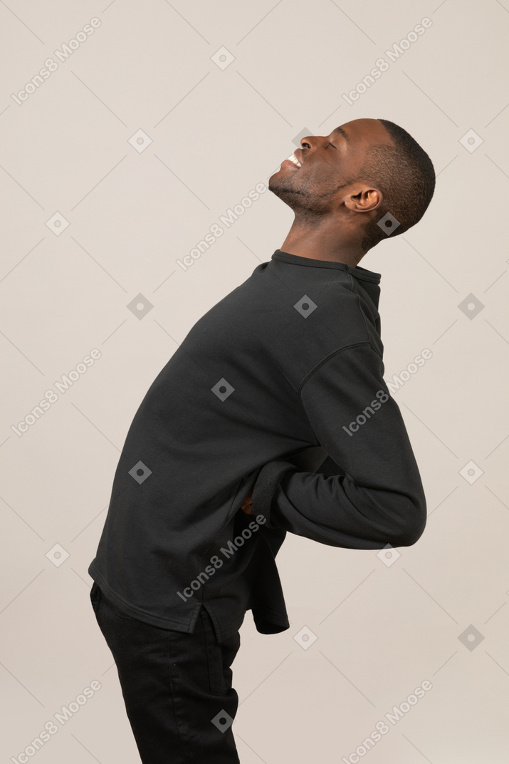 Side view of black man with eyes closed stretching backward