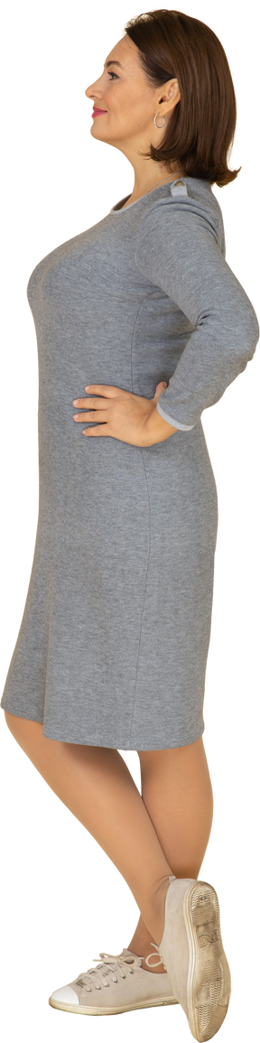 Vista lateral de uma mulher feliz em um vestido cinza