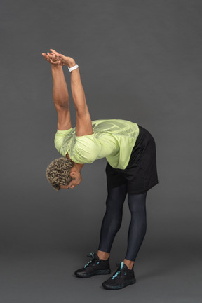Man leaning forward and stretching his arms behind his back