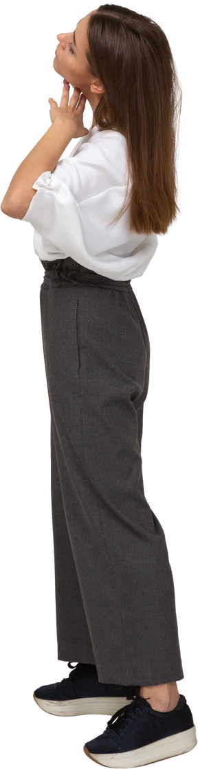 Side view of a young lady in office clothing touching her face