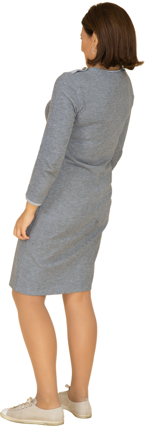 Femme en robe grise debout de profil